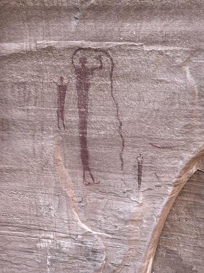 A solitary tall pictograph figure painted on a sandstone wall.